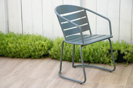 Single blue metal chair sitting on a nice patio deck